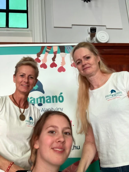 Az alapítvány csapata mosolyog a Mohamanó roll-up előtt