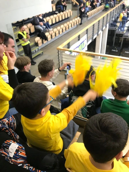 Gyerekek sárga pomponokkal egy kosárlabda meccsen
